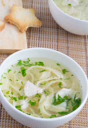 Chicken broth served with pasta and chopped parsley の写真素材