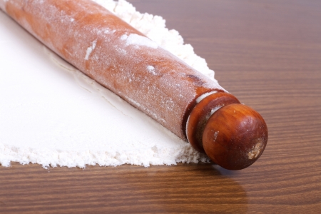 Wooden rolling pin and flour a close-up on kitchen surfacesの写真素材