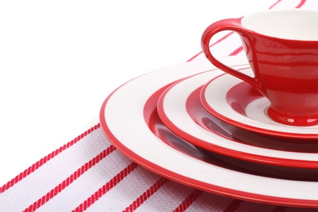 Table setting  Red plates and cups for tea on striped napkinの写真素材