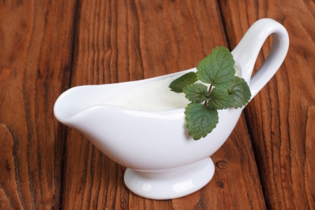 White bechamel with mint leaves on a wooden surfaceの写真素材