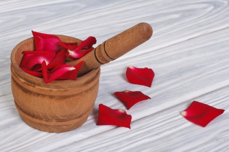 Red rose petals in a wooden mortar and pestleの写真素材