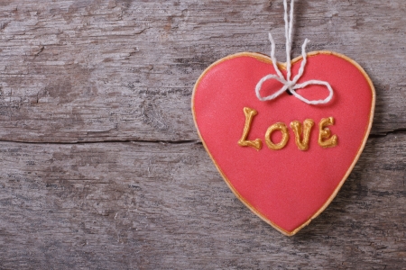 Red sweet cookies heart on background of the old board  Valentineの写真素材