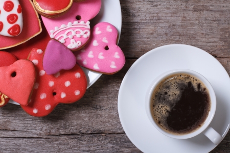 Black coffee and colorful heart cookies on a wooden table  top viewの写真素材