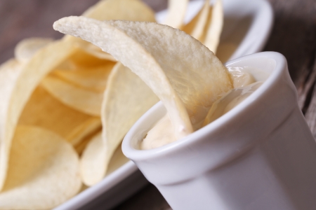 Potato chips in a white sauce on the old table macro close up. horizontal
の写真素材