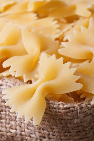 Farfalle pasta dry closeup on sackcloth. vertical. macro
の写真素材