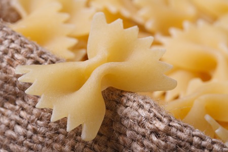 Farfalle pasta dry closeup on sackcloth. horizontal
の写真素材