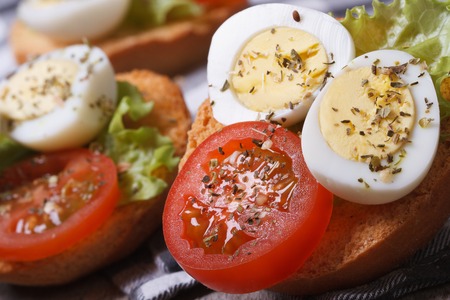 tasty useful sandwiches with boiled quail eggs, tomato and lettuce on the table. macro 
の写真素材