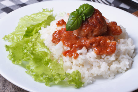 rice with meatballs, tomato sauce and lettuce