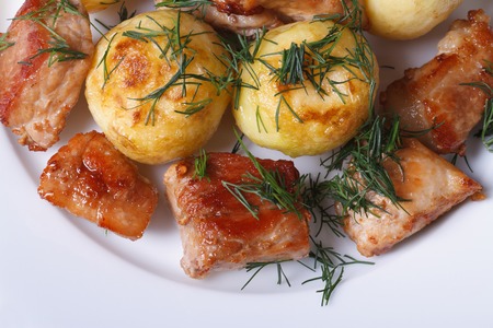 new potatoes with dill and fried slices pork on a white plate. top view 
の写真素材