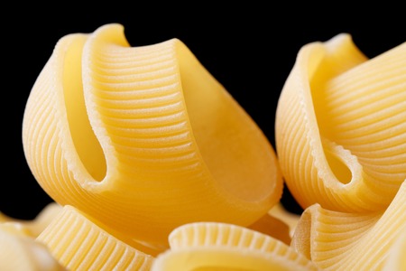 Uncooked italian pasta on black background close up horizontal, macro
の写真素材
