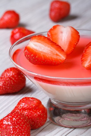 delicious panna cotta dessert in a glass and fresh strawberries on a wooden table. closeup. vertical 
の写真素材