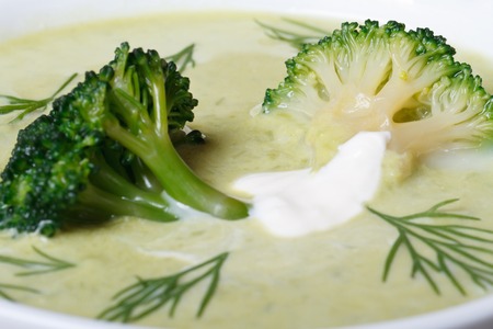 Broccoli puree soup with dill and sour cream in a white plate. macro. horizontal 
の写真素材