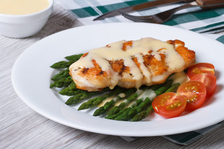 grilled chicken fillet with asparagus and sauce on a white plate horizontal の写真素材