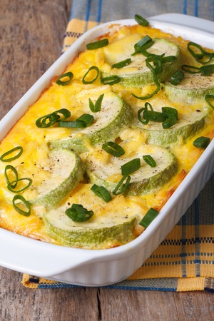 Zucchini baked with cheese, eggs and onion closeup in a white dish. vertical
の写真素材