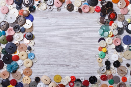 Frame of old buttons on wooden background close-up horizontal view from aboveの写真素材