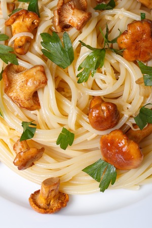 pasta with chanterelle mushrooms on a plate close-up top view of a verticalの写真素材