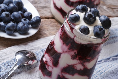 Yogurt with blueberries in a glass jar on the table closeup horizontal
の写真素材