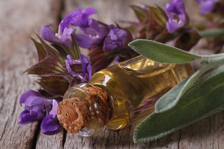 fragrant sage oil in a glass bottle on the table macro. の写真素材