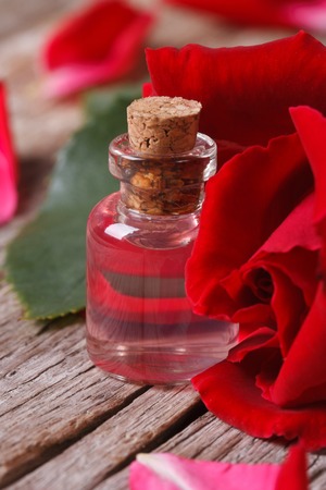 Rose water in a glass bottle on a background of red roses の写真素材