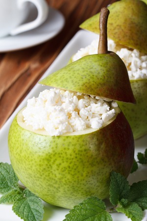ripe pears with cottage cheese and mint on a white plate closeup on table vertical の写真素材
