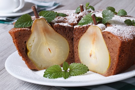 Delicious chocolate pie with whole pears and mint closeup on a white plate on the table horizontalの写真素材