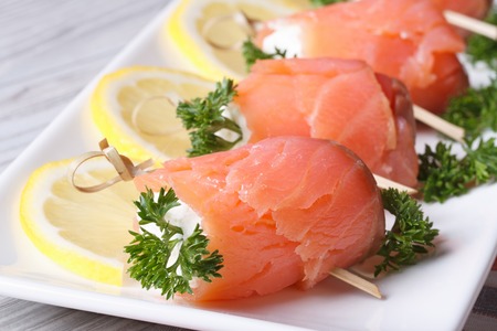 rolls with salmon, cream cheese and lemon closeup on a white plate horizontal
の写真素材