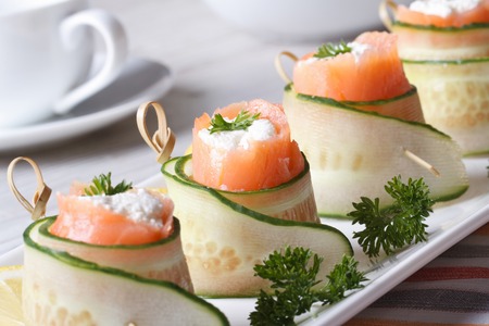salmon rolls with cucumber, cream cheese and herbs closeup on a white plate horizontal 
の写真素材