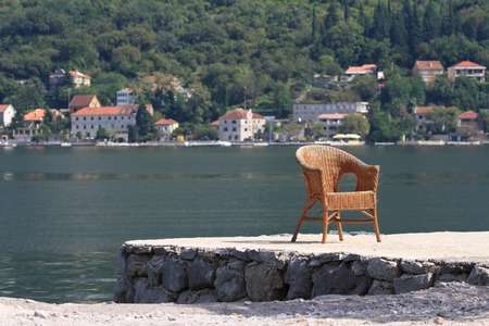 old wicker chair on the shore of the Bay of Kotor. Montenegroの写真素材