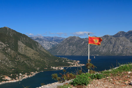National flag of Montenegro at the top of the hill above the Bay of Kotorの写真素材