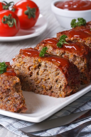 Meatloaf with ketchup closeup sliced on a white plate, verticalの写真素材
