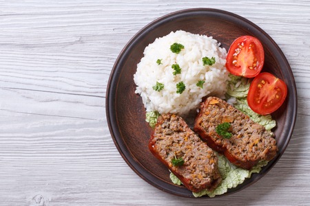 Delicious meat loaf with rice on a plate on the table, a horizontal top viewの写真素材