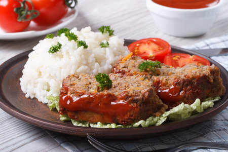 sliced meat loaf with rice and vegetables on a plate close-up, horizontalの写真素材