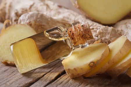 oil of ginger in a small glass bottle on a table close-up, horizontalの写真素材