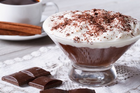chocolate mousse with whipped cream in a glass and coffee on the table close-up.の写真素材