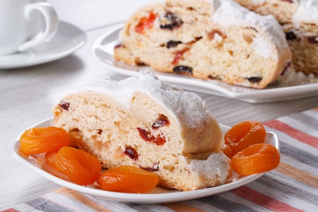 Traditional cake with raisins, dried apricots and candied slices closeup on a white plate. horizontalの写真素材