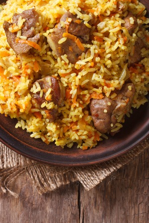 Rice with meat and vegetables on an old table macro. vertical view above, rustic styleの写真素材