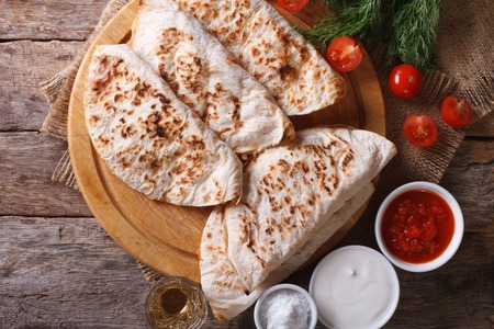 Quesadilla with sour cream and tomato sauce on a table close-up. horizontal view fromの写真素材