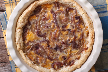 onion pie with cheese in baking dish on a table close-up. horizontal view from aboveの写真素材