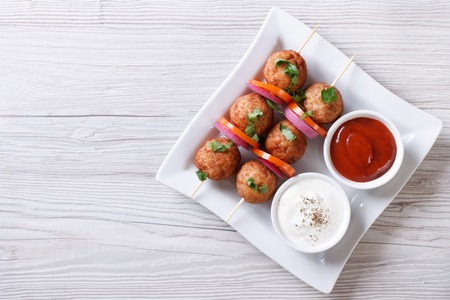 meatballs on skewers and sauces on the plate. horizontal view from aboveの写真素材
