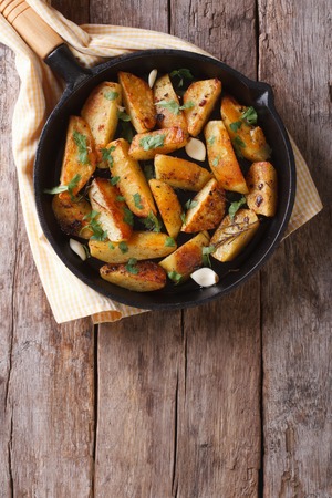potatoes baked in a pan, rustic style, vertical view from aboveの写真素材