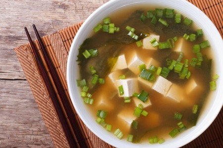 Japanese classic miso soup in a white bowl on the table close-up. horizontal view from aboveの写真素材