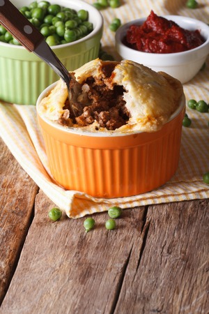 Tasty Australian meat pie in a pot on the table. Vertical close-upの写真素材