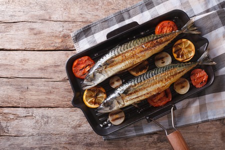 Grilled mackerel fish in a pan with vegetables. horizontal view from aboveの写真素材