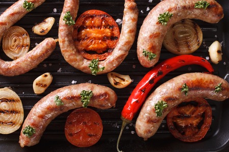 Grilled sausages with vegetables on a grill pan closeup. horizontal view from aboveの写真素材