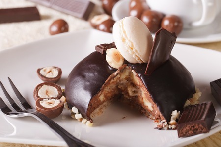Sliced chocolate cake decorated with nuts and macaroon on a plate. horizontalの写真素材