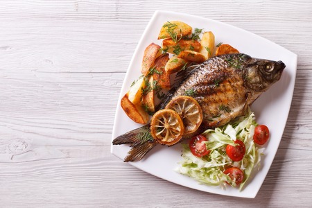 fried fish with fries and salad on a plate. horizontal view from aboveの写真素材