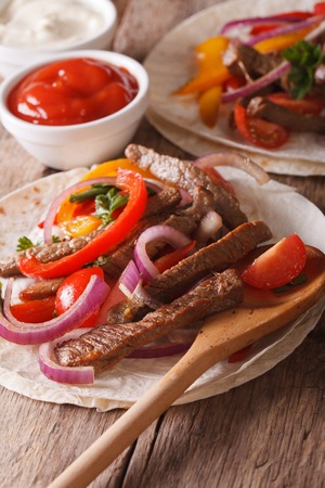 Mexican food: tortilla with meat and vegetables close-up. Vertical, rustic styleの写真素材