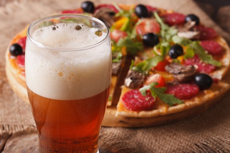 beer with foam close-up on background pizza on the table. horizontalの写真素材