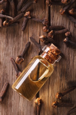 Oil of cloves in the bottle close-up on the table. vertical top viewの写真素材