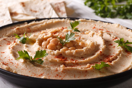 Vegetarian Hummus with paprika and parsley on the plate closeup